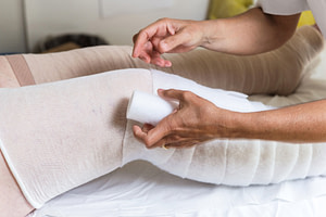 Manual Lymphatic Drainage (MLD) 1 MLD therapist applying multi-layered compression bandaging